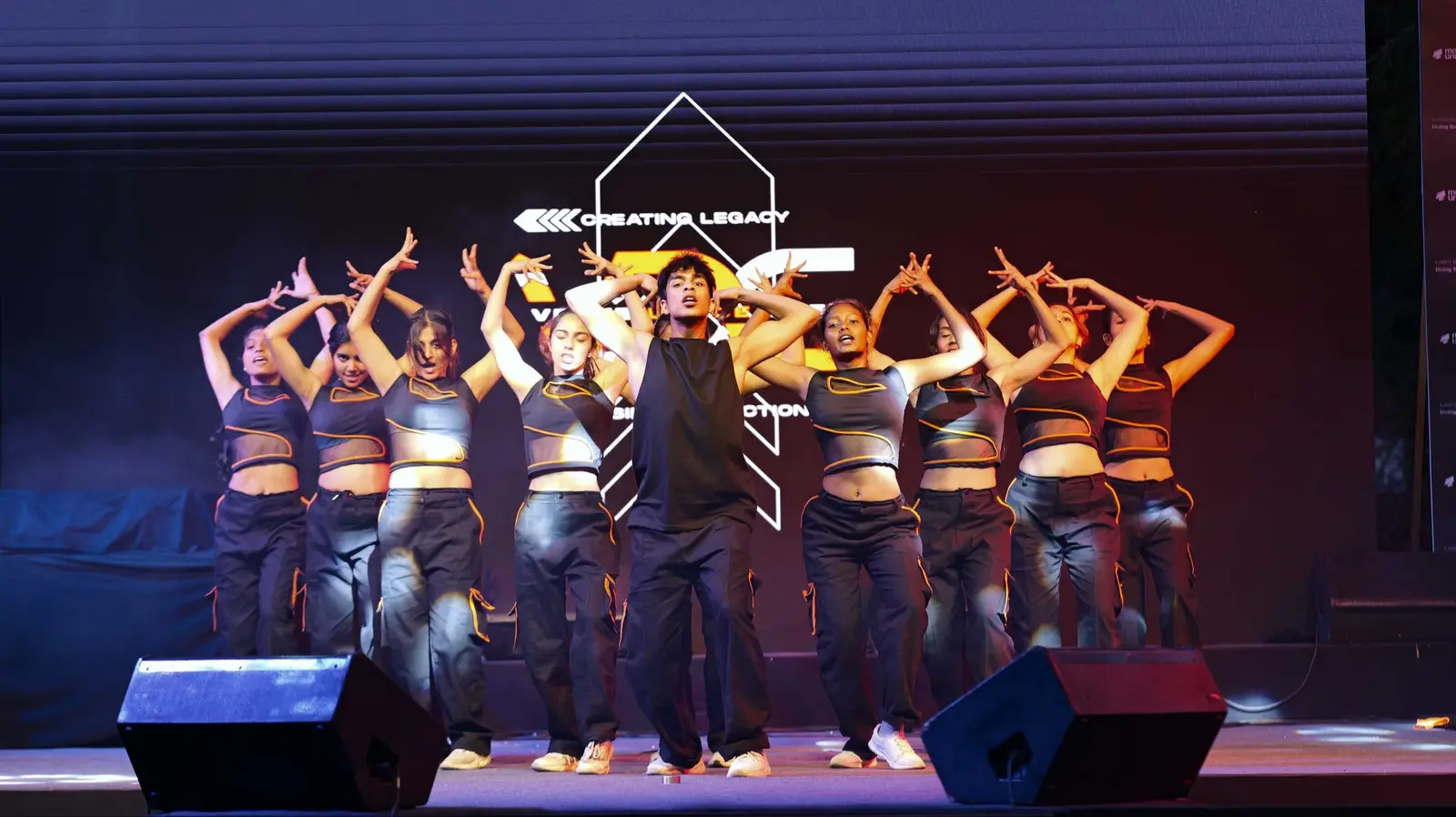 A dance troupe performing on a lit stage