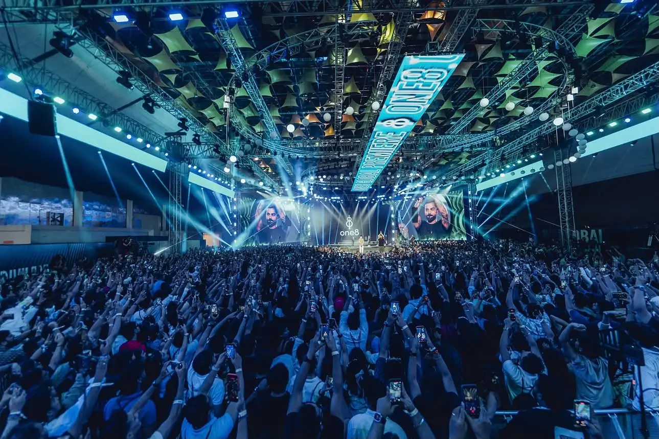 A packed hall facing a lit stage